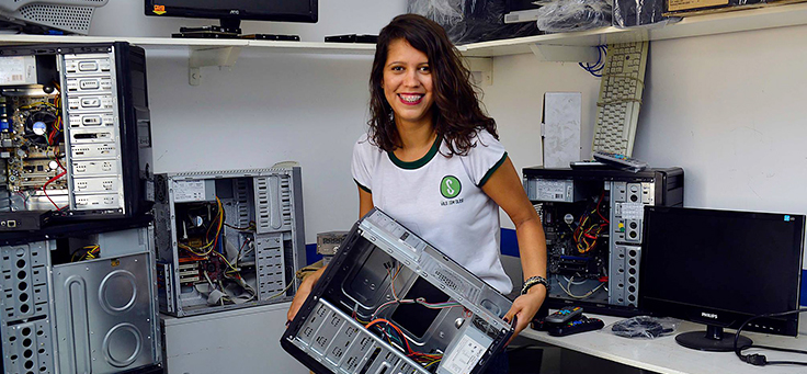 Marísia Maria Costa, é um das criadoras do projeto. Na imagem ela aparece segurando um computador