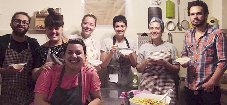 7 pessoas sorriem posando para foto usando avental