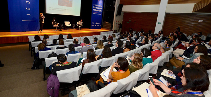 Pessoas na plateia assistem a painel no Jeduca