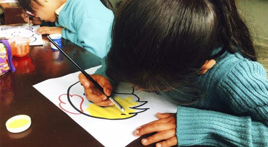 Criança desenha em folha de papel
