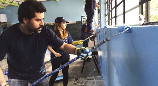 Voluntários pintam parede da escola Molino de Carmen, no Peru