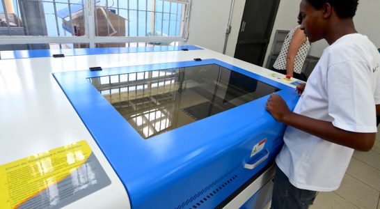 Jovem se apoia em mesa do Lab Maker Arrastão