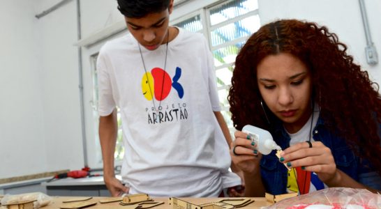 Jovens trabalham em mesa de moldes no Lab Maker Arrastão
