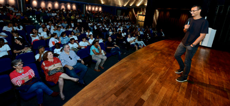 Eduardo Lyra apresenta palestra para plateia em palco