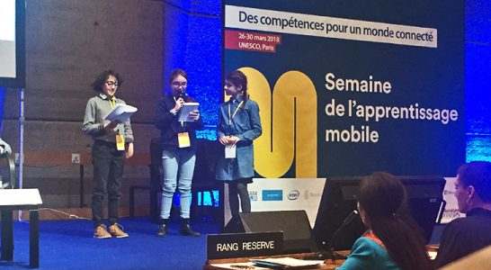 Alunos de escola francesa leem texto no palco do Mobile Learning Week