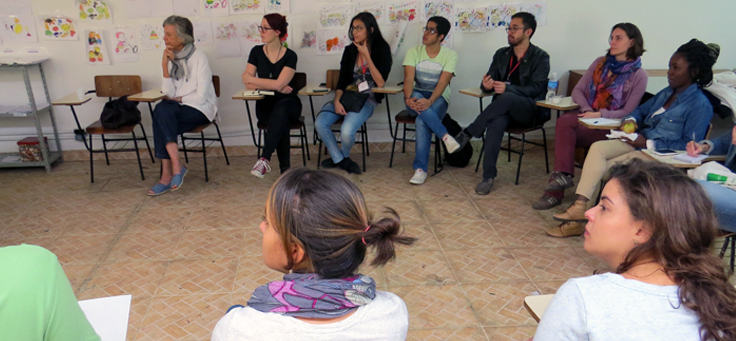 Imagem mostra pessoas em sentadas em roda em projeto sobre voluntariado como ponte entre o refugiado e seu novo país