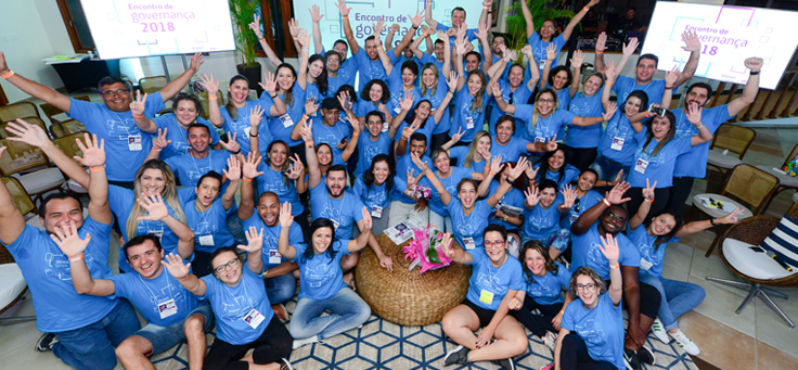 Voluntários do Grupo Telefônica Vivo formam círculo e posam para foto usando camisas na cor azul
