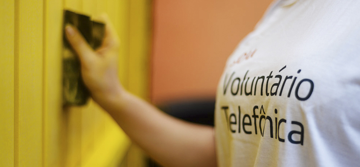 Pessoa com camiseta do Vaciones Solidarias, projeto de voluntariado internacional, está com as mãos segurando objeto