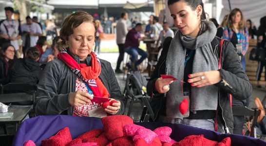 Duas mulheres pegam brindes do festival Social Good Brasil