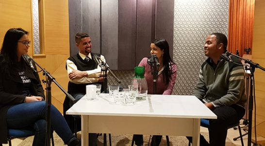 Quatro jovens conversam dentro de um estúdio de gravação
