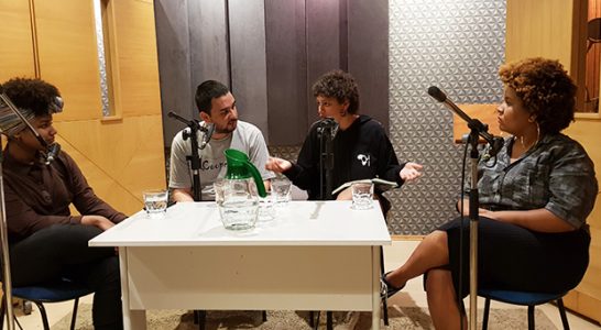 Quatro jovens conversam dentro de um estúdio de gravação