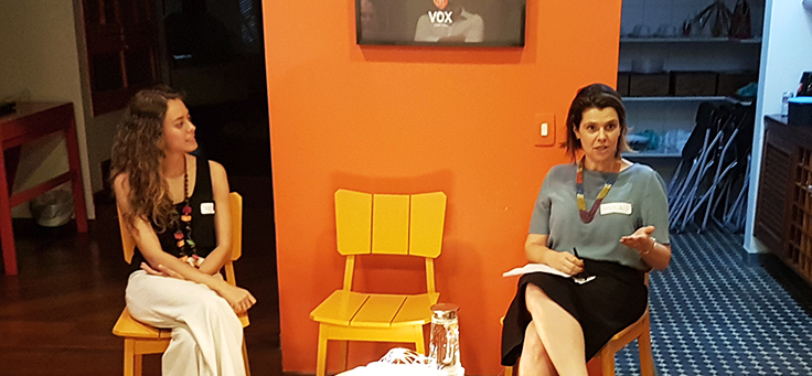 Mila Gonçalves, gerente de programas sociais da Fundação Telefônica Vivo está sentada em uma cadeira com as pernas cruzadas e falando sobre engajamento no evento Mobilizaí.