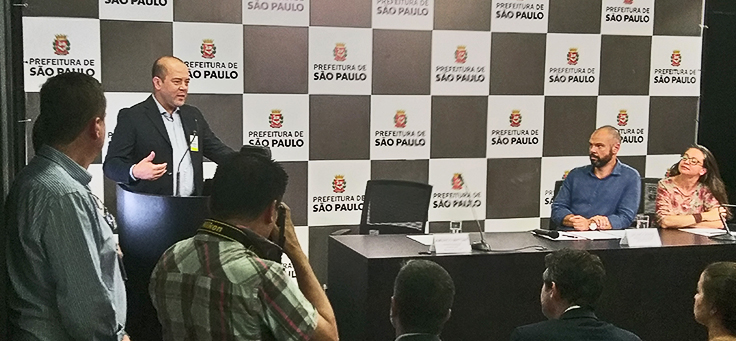 Americo Mattar, diretor-presidente da Fundação Telefônica Vivo, está falando ao microfone durante o encerramento do Vai Tec, com o prefeito Bruno Covas e a secretária Aline Cardoso ao fundo.