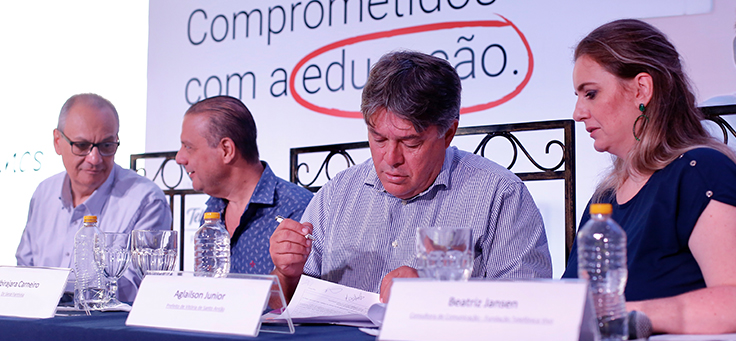 Imagem mostra a mesa de abertura do evento de inauguração do Aula Digital composta por, da direita para a esquerda: Beatriz Jansen, consultora da Fundação Telefônica Vivo; Aglaison Júnior, prefeito de Vitória de Santo Antão; Ubirajara Carneiro, diretor da FAINTVISA; e Helon Gouveia, representante da secretaria de educação