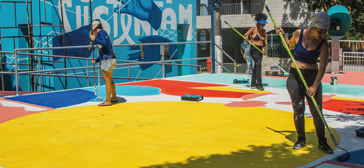 Equipe da Cidade Quintal, uma das iniciativas voluntárias da lista, está pintando uma quadra na cidade de Vitória.