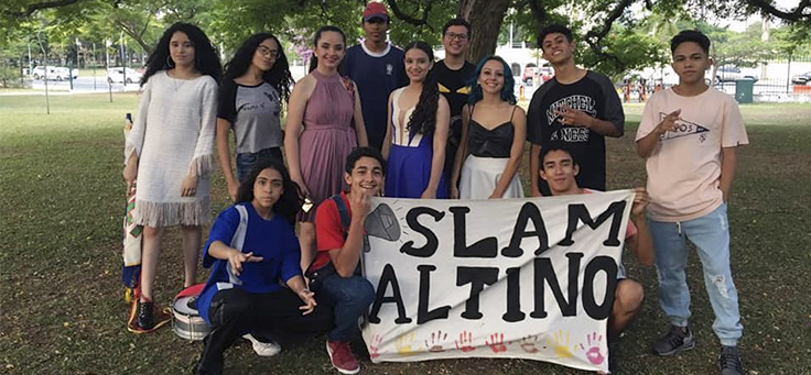 Alunos da Escola Municipal Altino Arantes posam para foto em grupo segurando uma faixa com os dizeres: Slam Altino