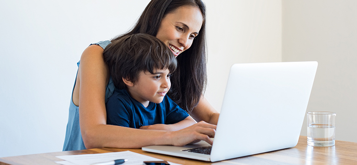 Imagem mostra mãe e filho olhando para um notebook