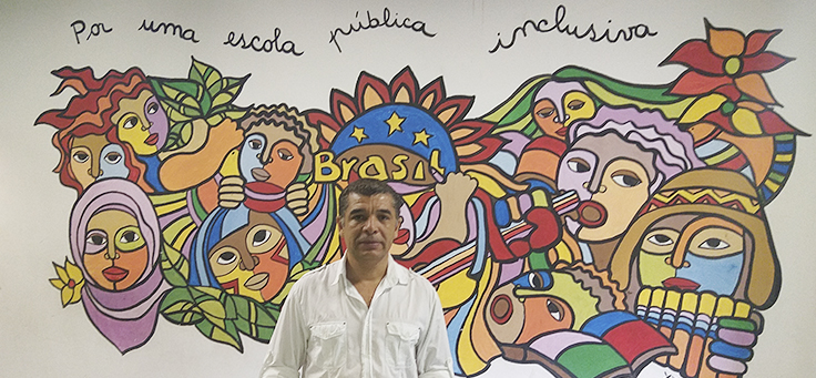 Imagem mostra um homem em frente a uma parede desenhada