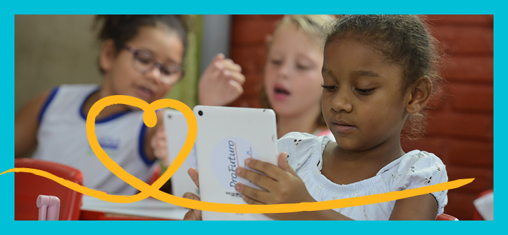 Imagem mostra uma criança em destaque olhando para um tablet onde se lê ProFuturo na parte de trás. Ao fundo é possível ver mais duas crianças.