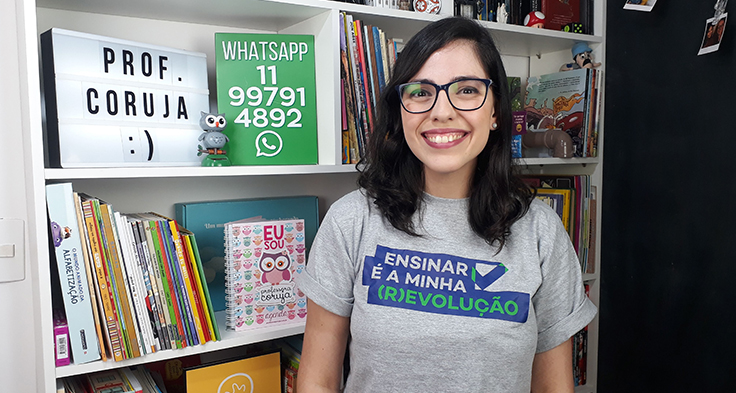 Lorena Carvalho, conhecida pelo canal Professora Coruja que foca em alfabetização e cultura digital. Ela está sorrindo e usando uma camiseta com a frase “Ensinar é a minha (R)evolução”.