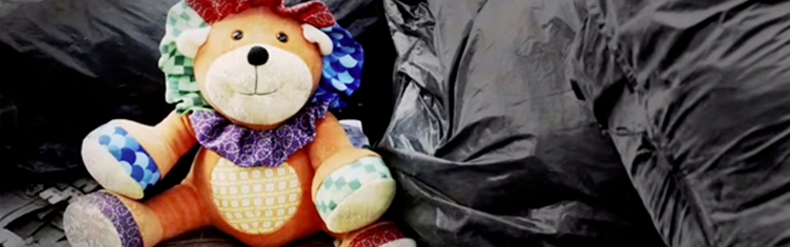 urso de pelúcia sobre sacos de lixo pretos simbolizando trabalho infantil