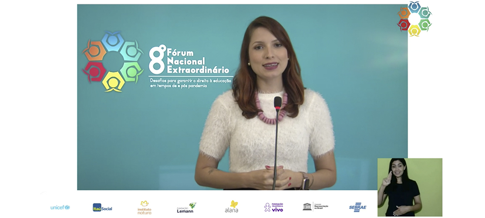 Imagem mostra apresentadora vestindo branco em um evento online. Ao fundo, se vê o logo do 8º Fórum Nacional Extraordinário – Desafios para garantir o direito à educação em tempos de e pós pandemia