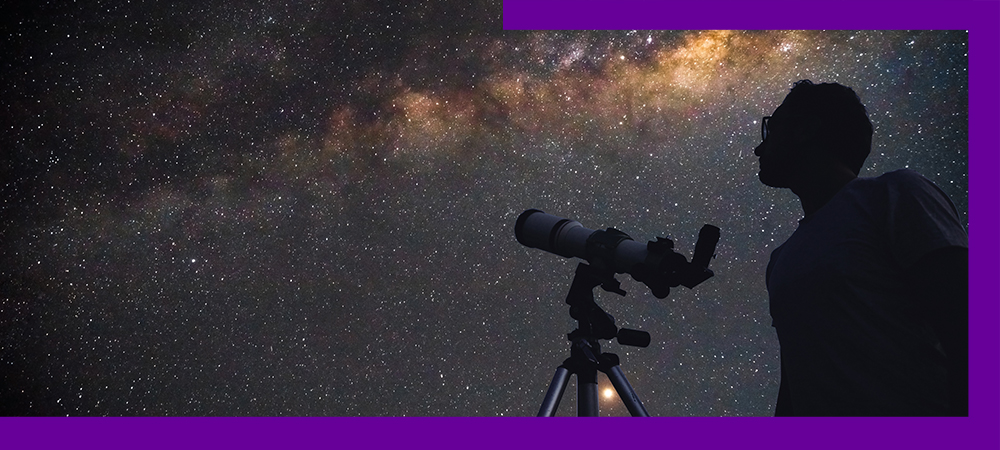 Imagem mostra a silhueta de um homem próximo a um telescópio, olhando para um céu estrelado
