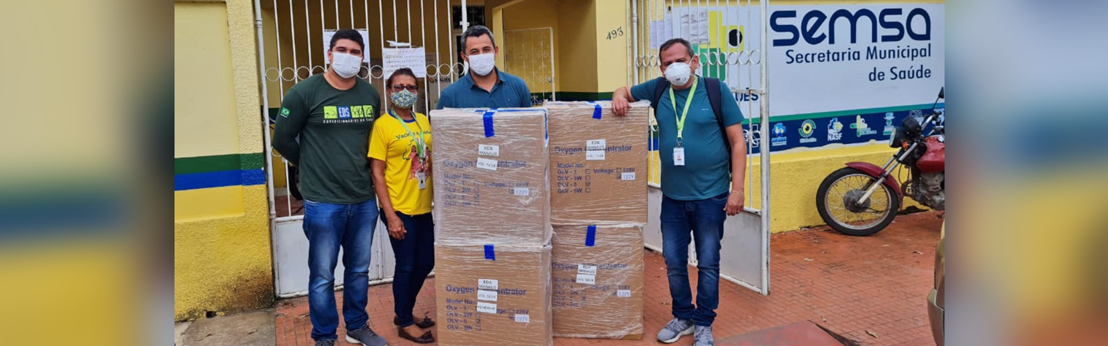 Imagem mostra um grupo usando máscaras de proteção e posando para a foto atrás de várias caixas de papelão com equipamentos médicos doados pela Fundação Telefônica Vivo em ação emergencial de apoio ao Amazonas