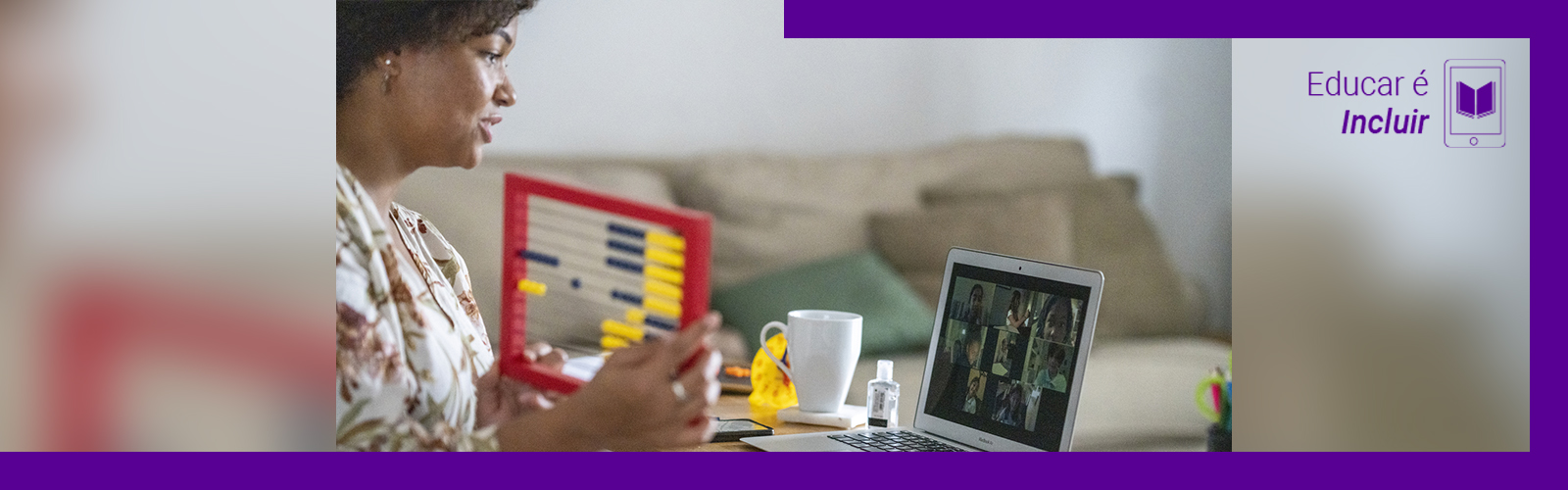 A imagem mostra uma mulher na sala de sua casa, sentada em frente a uma mesa onde está um computador, um ábaco e uma xícara de porcelana. Ela está olhando para tela e interagindo com um grupo de pessoas em uma videoconferência
