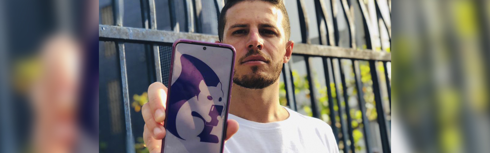 Plataforma New School une voluntariado e educação para ajudar jovens da periferia. Na imagem, Jotapê, o fundador da iniciativa está segurando um celular que mostra uma das telas do aplicativo.