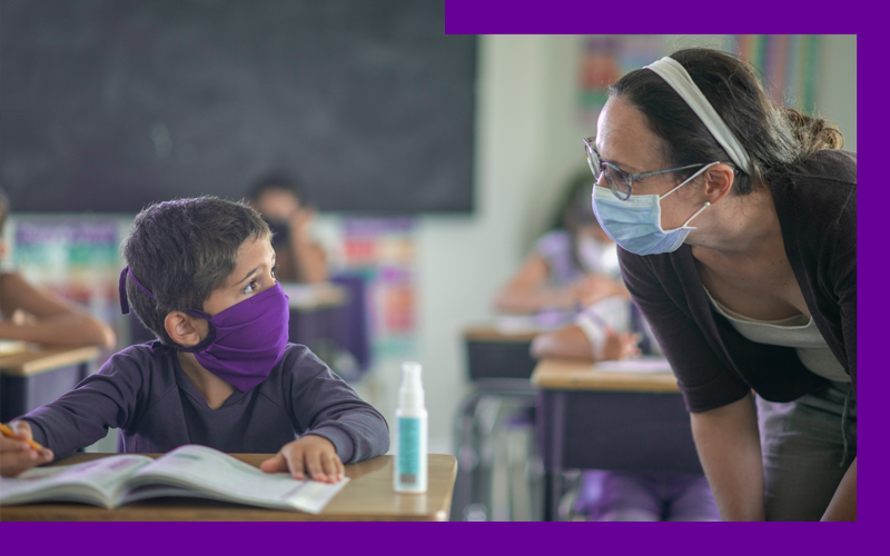 Imagem de uma educadora conversando com um aluno, os dois de máscara (texto estrutura escola pública)