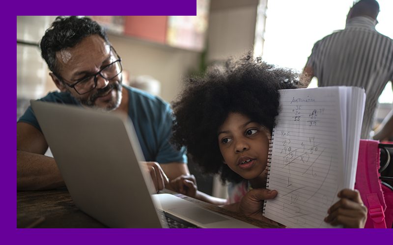 imagem mostra um pai e uma filha na sala de casa, mostrando o modelo ensino híbrido que mescla momento on-line e presencial