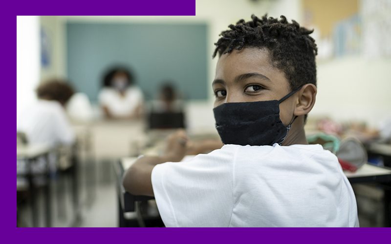 imagem de um estudante na sala de aula usando máscara de proteção facial