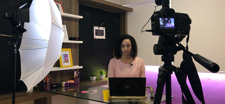Ludmila Hastenreiter, que criou a Empoderamento Contábil para empoderar mulheres, está sentada ao computador sendo gravada por câmera.