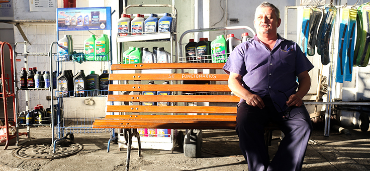 André de Aquino Pinto sentado em um banco do posto de gasolina, do qual trabalha como gerente.