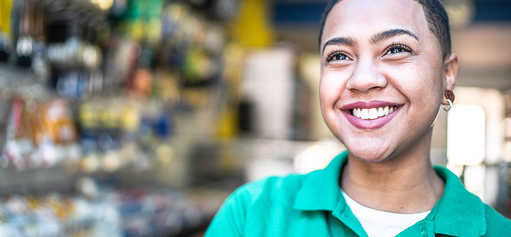 Imagem mostra uma jovem de camisa polo verde sorrindo
