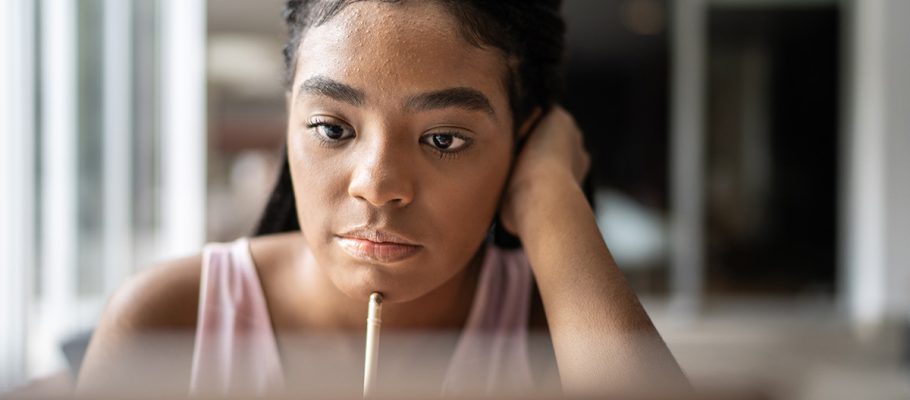 Jovem olha fixamente para tela de computador enquanto apoia lápis no rosto para ilustrar pauta sobre futuro do trabalho. Pesquisa da Unicef aponta visão de jovens sobre educação e emprego