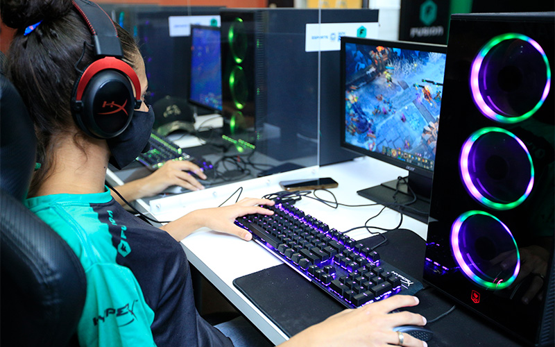 Imagem mostra uma jovem utilizando um computador. Na tela, é possível ver um jogo on-line. A jovem é uma das alunas do projeto para capacitar jovens na programação de jogos.