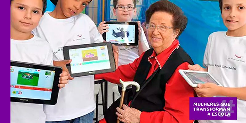 Léa Fagundes, professora pioneira da educação digital em sala de aula ao lado de alunos em uma escola