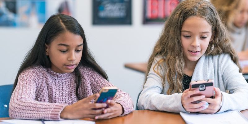 Imagem mostram adolescentes acessando o celular para fazer simulações