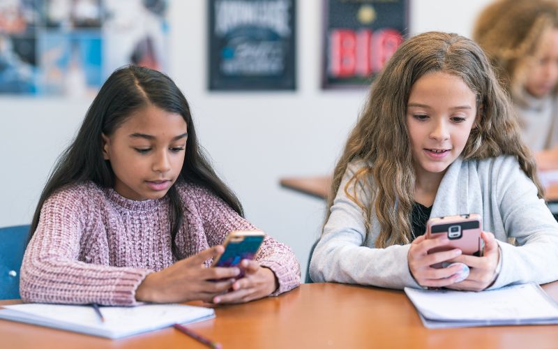 Imagem mostram adolescentes acessando o celular para fazer simulações