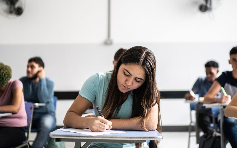 Imagem mostra a estudantes em sala de aula