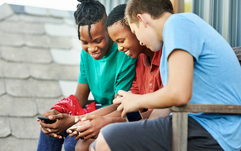Três adolescentes utilizam smartphones