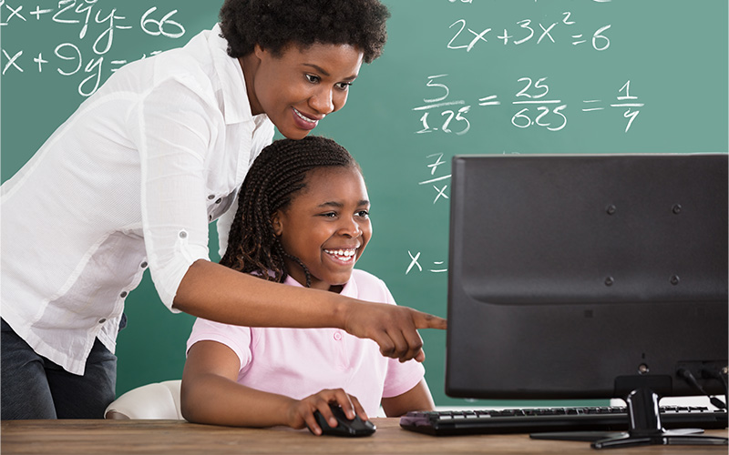 Professora e aluna diante de computador.