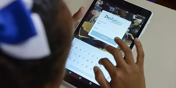 Criança em sala de aula manueia tablets do projeto Aula Digital ProFuturo em Vitória de Santo Antão