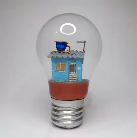 Foto de uma das obras de Nenê: uma casinha dentro de uma lâmpada.